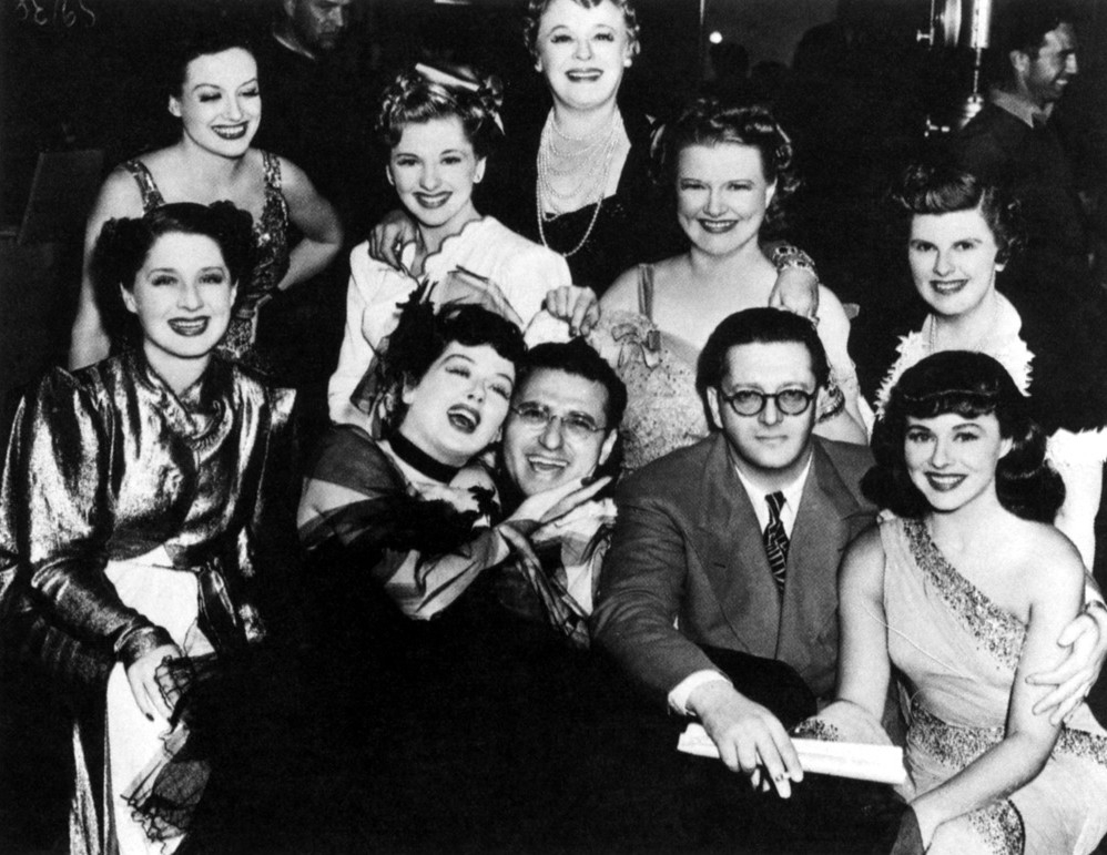 1939. On the set of 'The Women' with cast, director Cukor, and producer Hunt Stromberg.