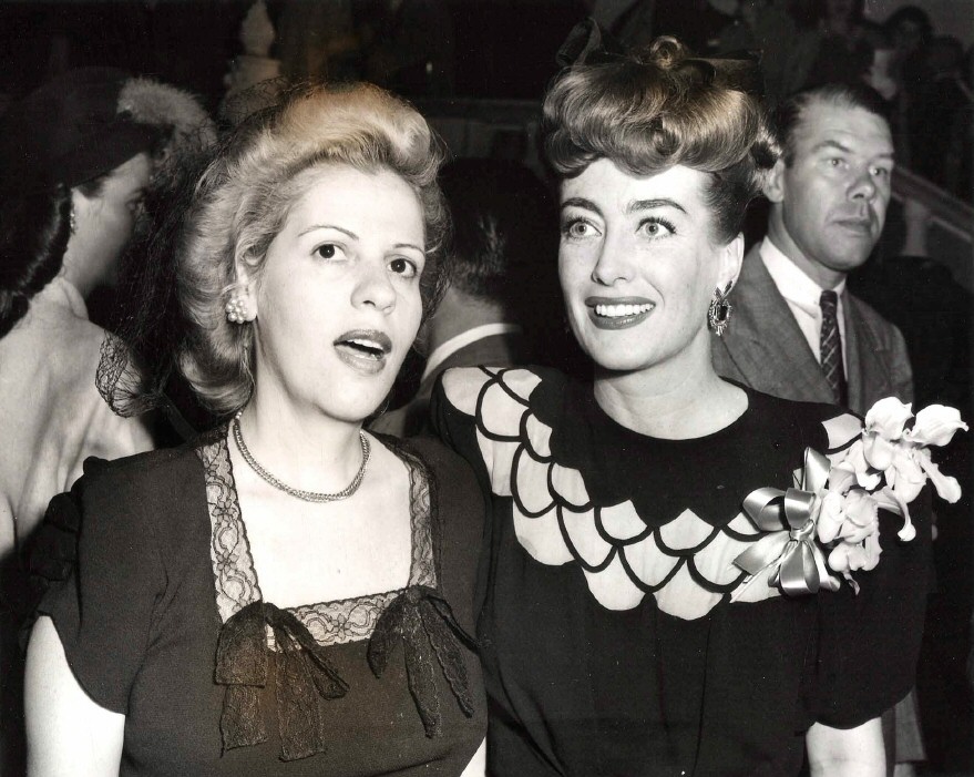 1945. At a Warners reception for Joan at NYC's Sherry-Netherland hotel, with Radie Harris.
