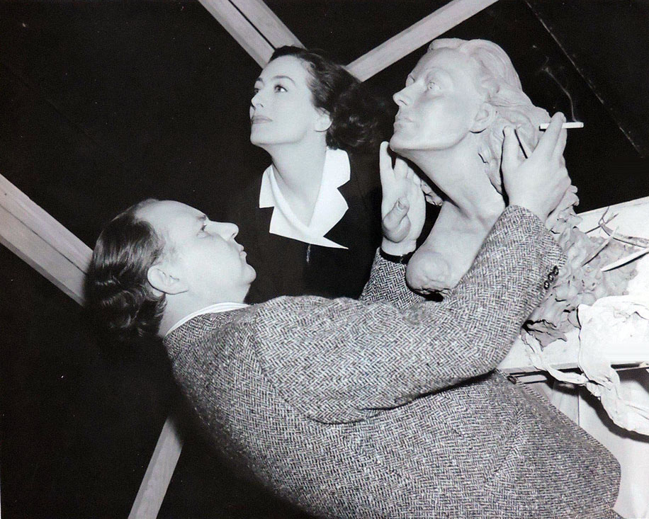 1941. On the set of 'A Woman's Face' being sculpted by Yucca Salamunich.