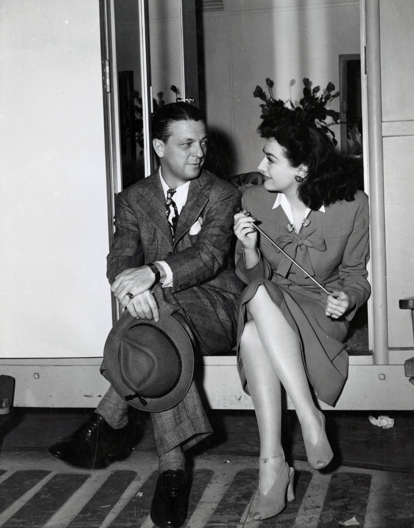 1942. On the set of 'They All Kissed the Bride' with the film's director Alexander Hall. Shot by Irving Lippman.