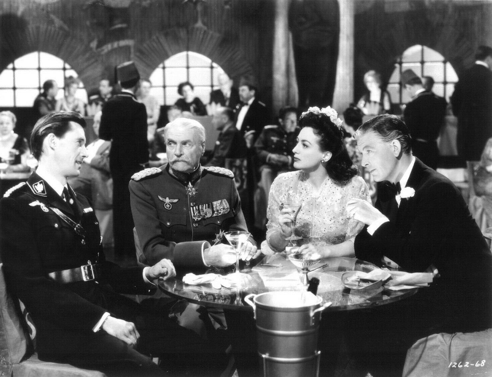 1942. 'Reunion in France.' With John Carradine, Albert Bassermann, and Philip Dorn.