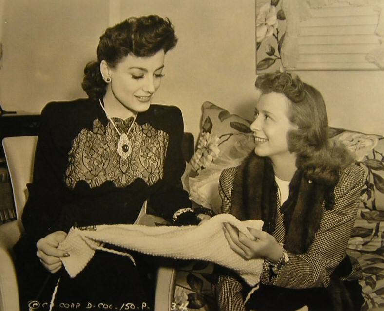 1942. On the set of 'They All Kissed the Bride' with starlet Gretchen Davidson.