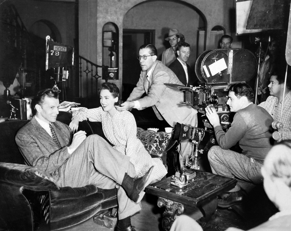 1945. On the set of 'Mildred Pierce' with Bruce Bennett and cast.