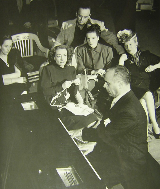 1946. On the set of 'Humoresque,' listening to pianist Jose Iturbi.