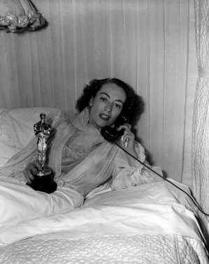 3/7/46. At home with her new Oscar for 'Mildred Pierce.'
