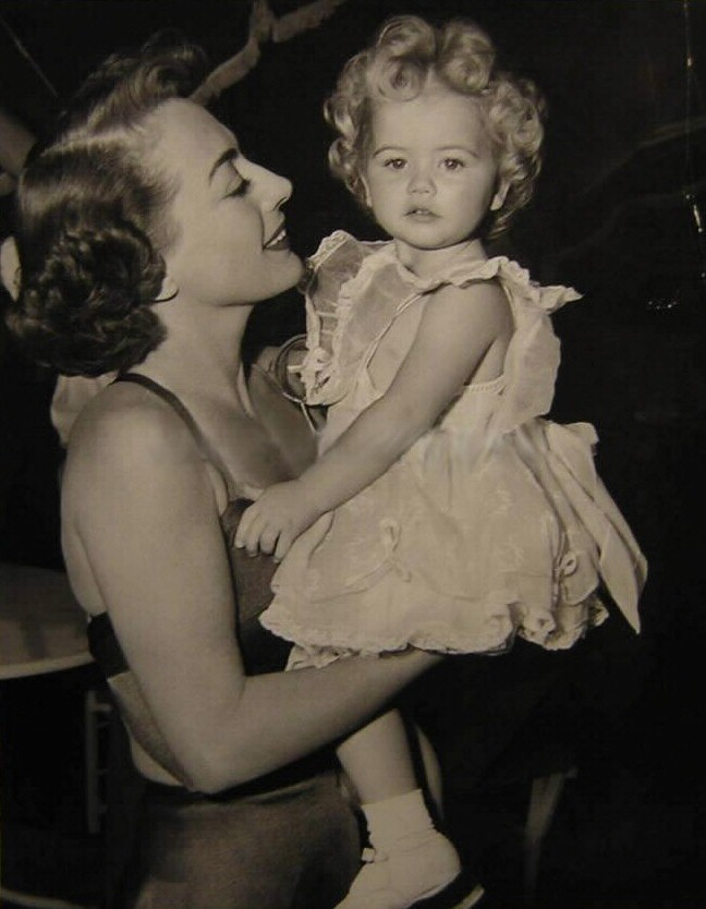 1950. On the set of 'The Damned Don't Cry' with unknown tot.