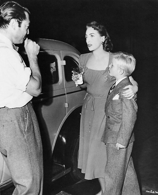 1950. On the set of 'The Damned Don't Cry' with director Sherman and son Christopher.