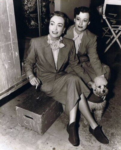 1950. 'Harriet Craig.' On the set with her stand-in. And poodle. And booties.