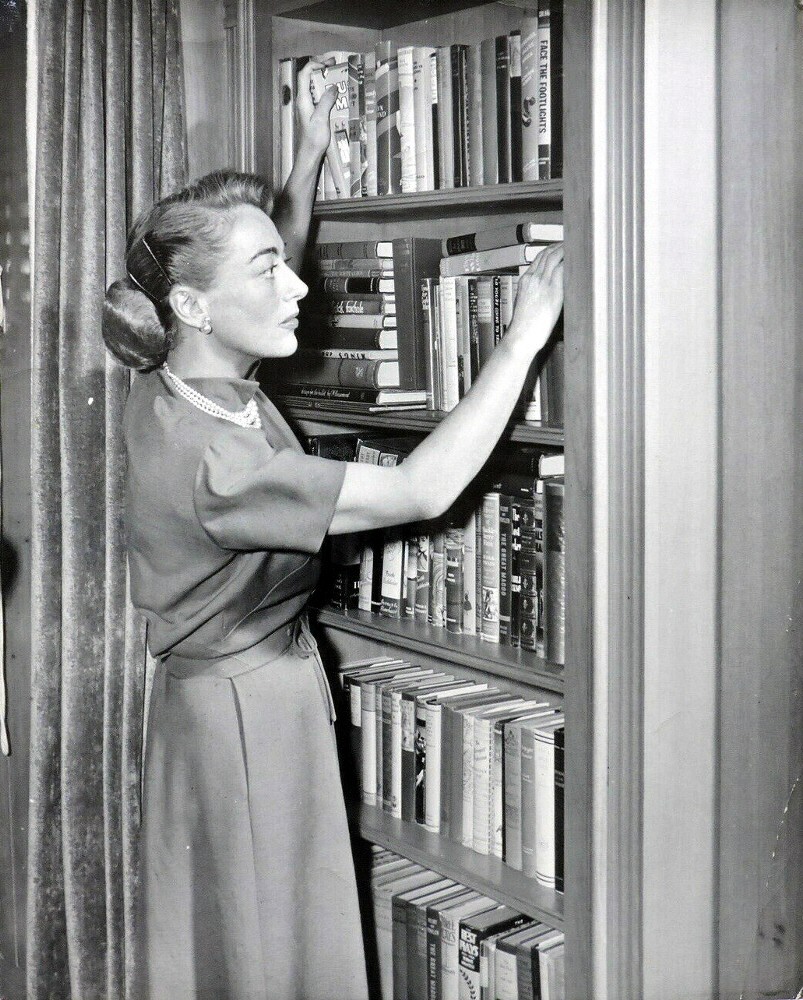 Circa 1950. At home with books.