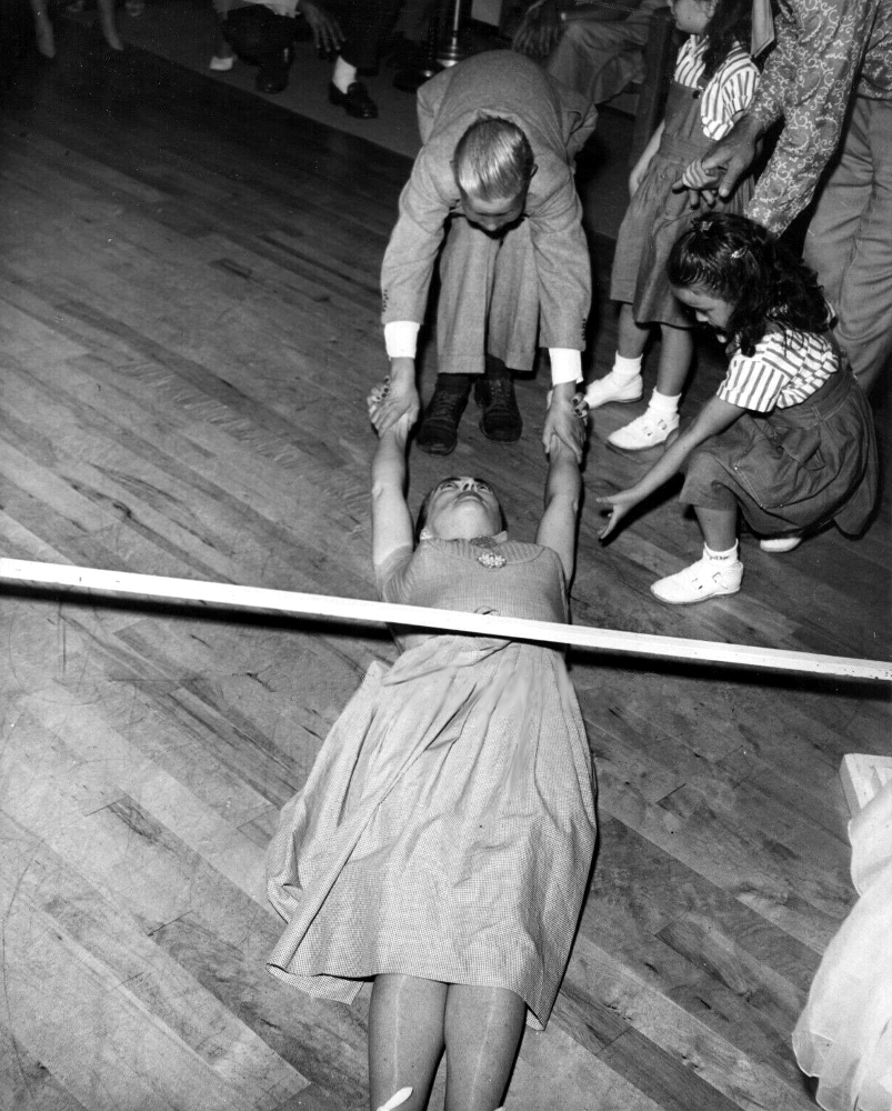 1953. Doing the limbo with help from Christopher. Shot by Len Weissman.