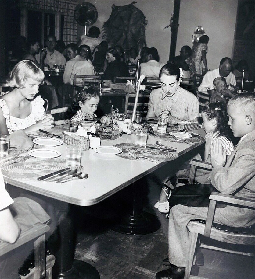 Circa 1953. Saying grace before dinner at a restaurant, with the kids.