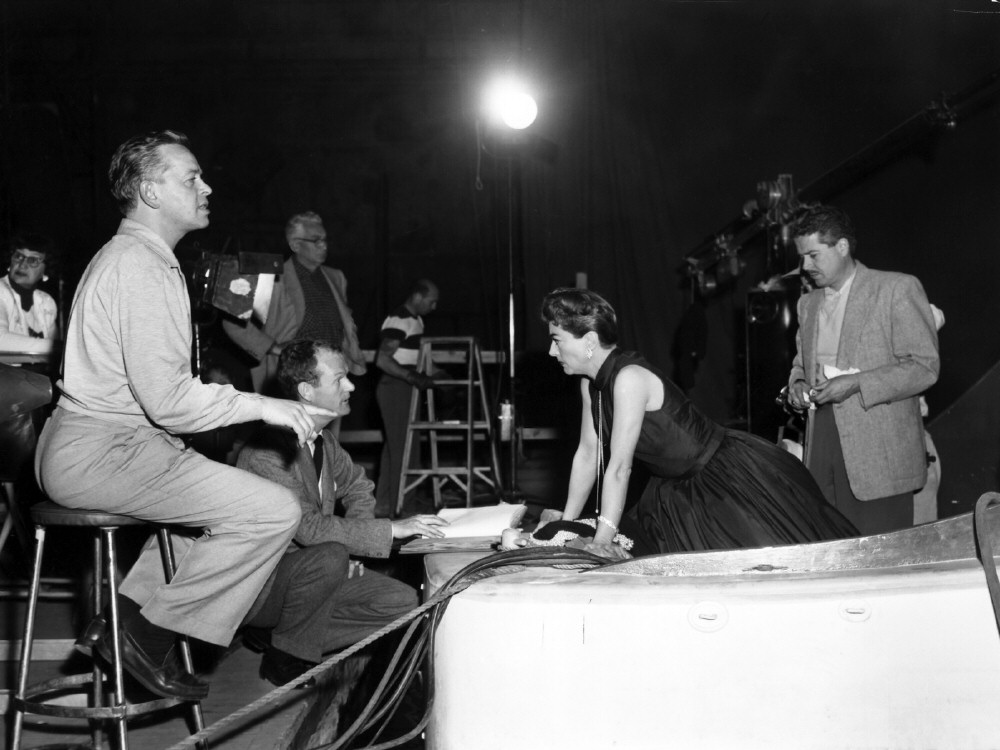 1955. On the set of 'Female on the Beach' with director Pevney, left.