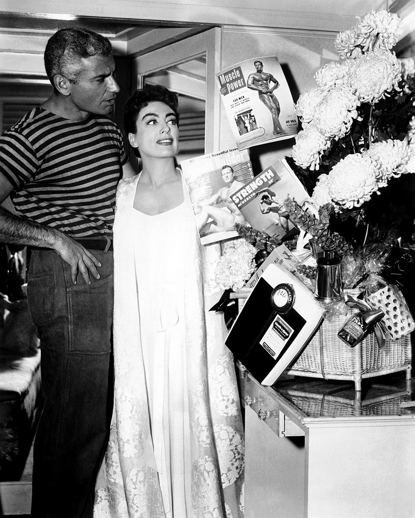 1955. On the set of 'Female on the Beach' with Jeff Chandler.