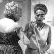 Life magazine, 10/05/59. After a party at her apt. for West Nigerian Pepsi bottlers. Original caption: 'Then with her skirt off and most of her guests gone, she chats with Mrs. [Frances] Spingold while cleaning up the kitchen--a job that had already been done by the servants. Next day the job was done a third time by special cleaners. For Joan insists on having a spotless and sparkling house.' By Eve Arnold.