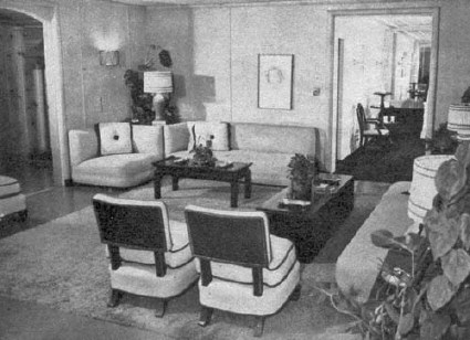 Most of Joan's entertaining is done in this playroom. The wall covering is leather, the built-in couches are sturdy, the lamps out of elbow reach. Joan's gold Oscar and Jean Negulesco's sketch of her are here. 