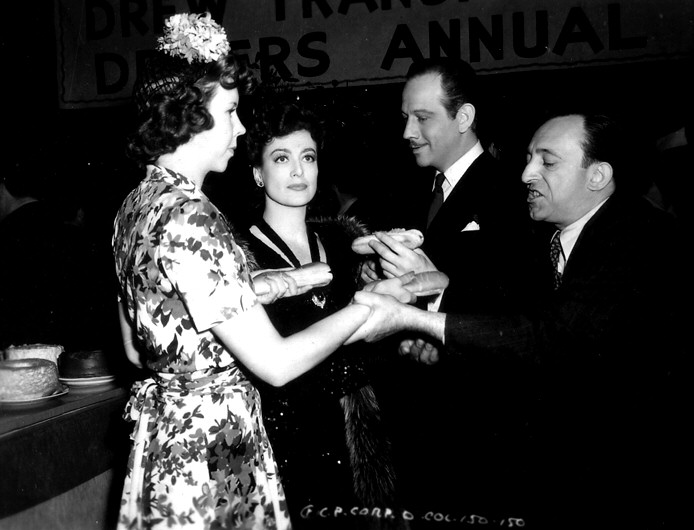 1942. On the set of 'They All Kissed the Bride' with Mary Treen and Melvyn Douglas.