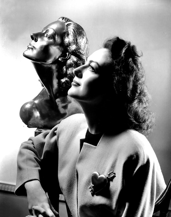 1941. With a sculpture of herself by Yucca Salamunich, presented to her on the set of 'A Woman's Face.'