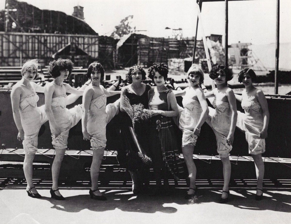 1926. On the set of 'The Boob' with co-star Gertrude Olmstead (center) and dancers.