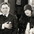 1926. On the set of 'Paris' with co-star Charles Ray, director Edmund Goulding, and NYC producer Morris Gest. (Includes press caption.)