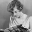 1929. On the set of 'Duke Steps Out.' Reading a copy of 'Film Weekly' with herself on the cover!