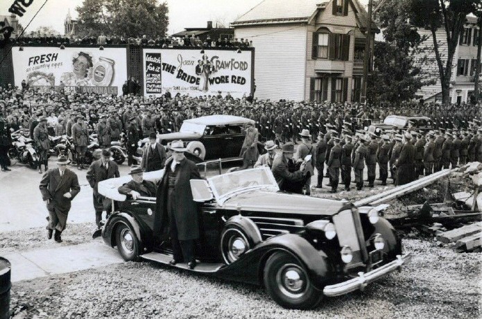 President Roosevelt in Poughkeepsie, NY, to lay post office cornerstone. With Joan 'Bride Wore Red' billboard as backdrop.