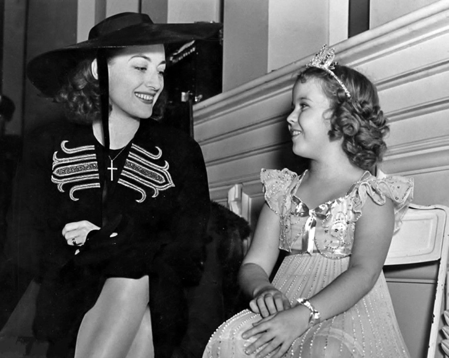 1938. On the set of 'Little Miss Broadway' with Shirley Temple.