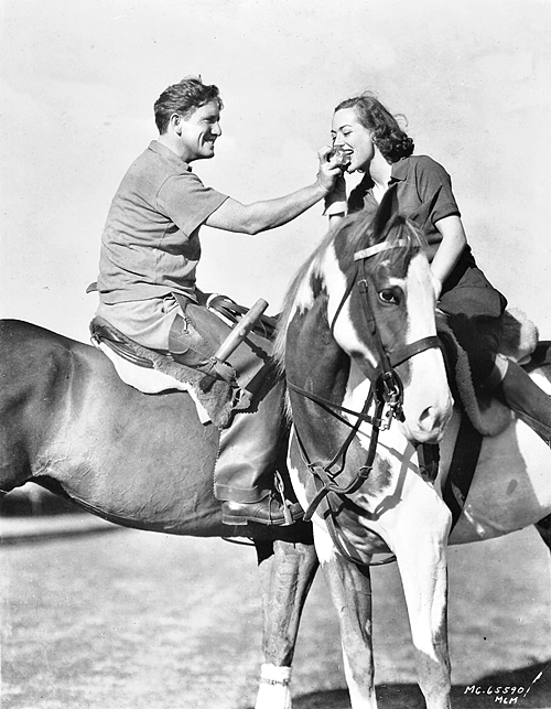 February 1938, with Spencer Tracy. (Her polo pony is a gift from him.)