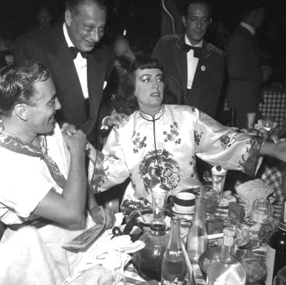 1954. At the Press Photographers' Ball with Cesar Romero (left).