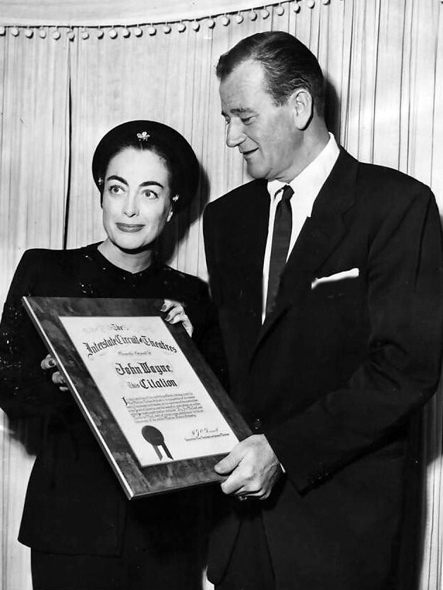 1952. Presenting John Wayne with Interstate Circuit of Theatres award.