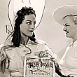 On the set of 'Hussy,' Texan Joan receives a certificate from a Rangerette in honor of Texas's 100th year of independence. Clicking this link will take you to 2 pictures.